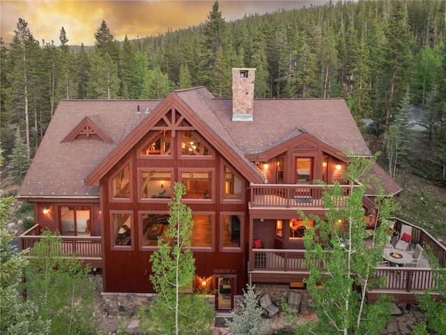 66 Chaparral Ln, Breckenridge, CO 80424 - back of house featuring a wooded view, a chimney, and a wooden deck