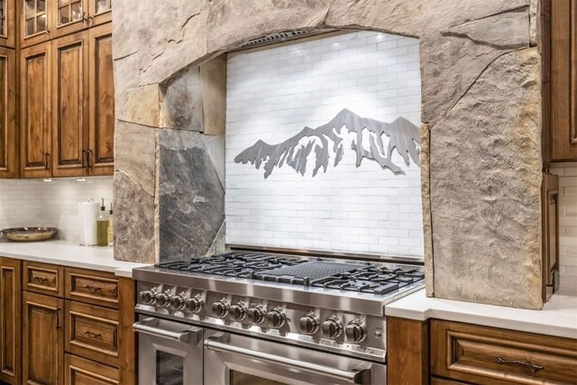 242 Point View Pl, Breckenridge, CO 80424 - kitchen with double oven range, backsplash, brown cabinets, light countertops, and glass insert cabinets