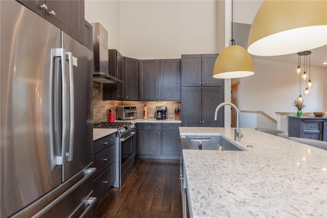 22 Vernon Way, Silverthorne, CO 80498 - kitchen featuring appliances with stainless steel finishes, wall chimney exhaust hood, tasteful backsplash, dark wood-style floors, and decorative light fixtures