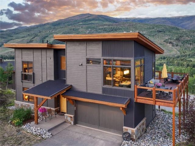 22 Vernon Way, Silverthorne, CO 80498 - rear view of property featuring a mountain view, an attached garage, driveway, and stone siding