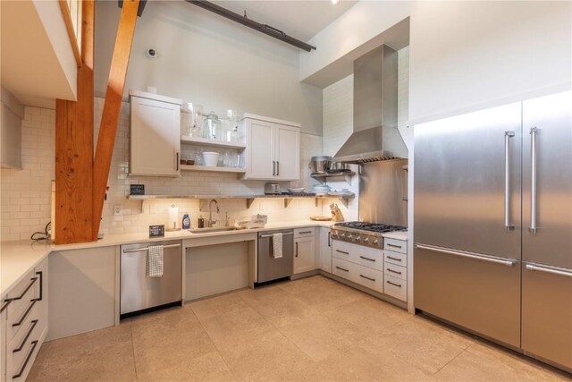 22 Vernon Way, Silverthorne, CO 80498 - kitchen with wall chimney range hood, appliances with stainless steel finishes, decorative backsplash, light countertops, and a towering ceiling