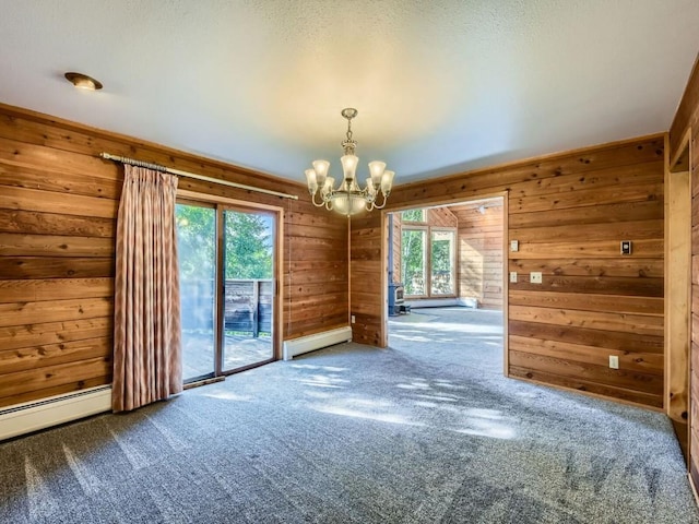 134 Hideaway Ct, Dillon, CO 80435 - unfurnished room with a baseboard heating unit, wood walls, carpet, and a chandelier