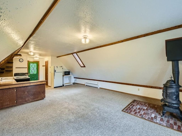 134 Hideaway Ct, Dillon, CO 80435 - unfurnished living room featuring a wood stove, carpet, a textured ceiling, a baseboard heating unit, and vaulted ceiling