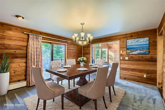 134 Hideaway Ct, Dillon, CO 80435 - dining room featuring a chandelier, a baseboard radiator, wood walls, and dark colored carpet