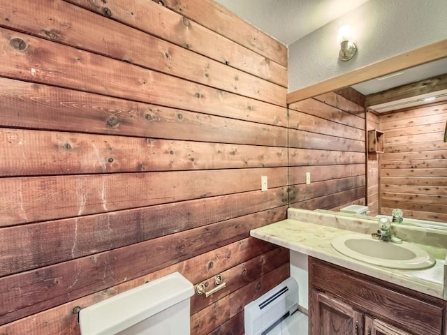 134 Hideaway Ct, Dillon, CO 80435 - half bathroom with a baseboard heating unit, wooden walls, and vanity