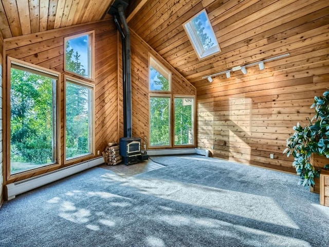 134 Hideaway Ct, Dillon, CO 80435 - unfurnished living room with a baseboard heating unit, wooden ceiling, a wood stove, vaulted ceiling, and carpet
