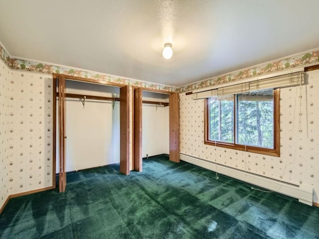 134 Hideaway Ct, Dillon, CO 80435 - unfurnished bedroom with a baseboard heating unit, wallpapered walls, dark carpet, and multiple closets