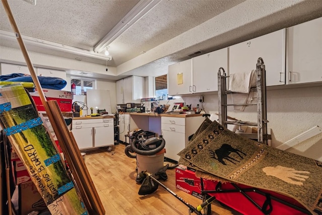726 Cumberland Dr, Jefferson, CO 80456 - kitchen with white cabinetry, a textured ceiling, and light wood-style flooring