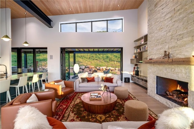 33200 Meadow Creek Dr, Steamboat Springs, CO 80487 - living area with a wood ceiling with exposed beams, wood finished floors, a high ceiling, and a stone fireplace