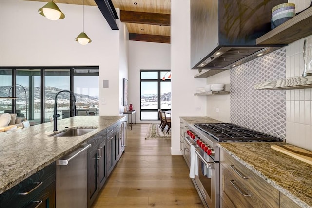 33200 Meadow Creek Dr, Steamboat Springs, CO 80487 - kitchen featuring stainless steel appliances, range hood, open shelves, backsplash, and light stone countertops
