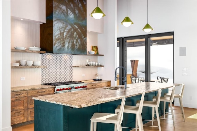 33200 Meadow Creek Dr, Steamboat Springs, CO 80487 - kitchen with open shelves, backsplash, high end range, light wood-style floors, and decorative light fixtures