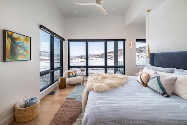 33200 Meadow Creek Dr, Steamboat Springs, CO 80487 - bedroom featuring wood finished floors, multiple windows, ceiling fan, a mountain view, and recessed lighting