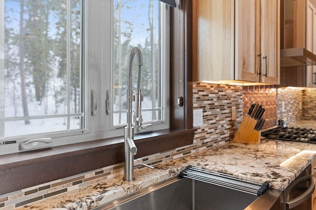 740 Cirrus Way, Granby, CO 80446 - kitchen featuring backsplash, wall chimney exhaust hood, light stone countertops, and stainless steel gas stovetop