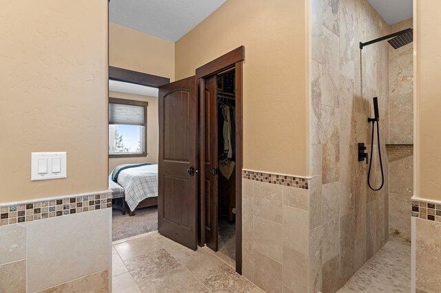 740 Cirrus Way, Granby, CO 80446 - bathroom with tile walls, wainscoting, and a walk in shower