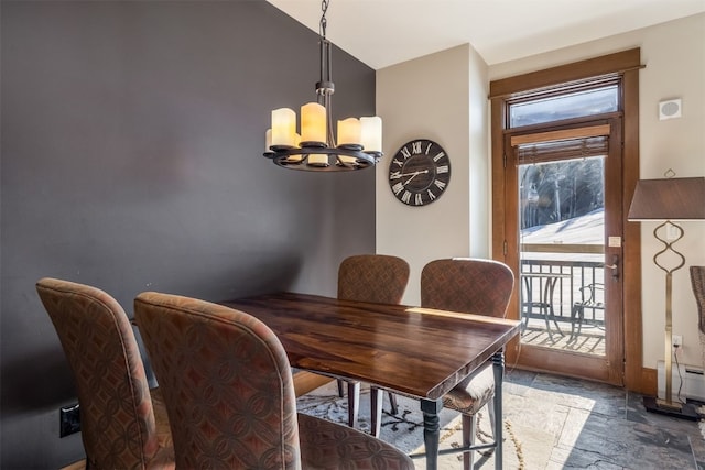 dining room featuring a baseboard heating unit, vaulted ceiling, stone finish flooring, and an inviting chandelier