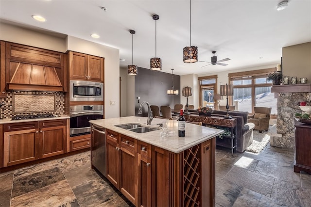 kitchen featuring appliances with stainless steel finishes, stone tile floors, a sink, and tasteful backsplash