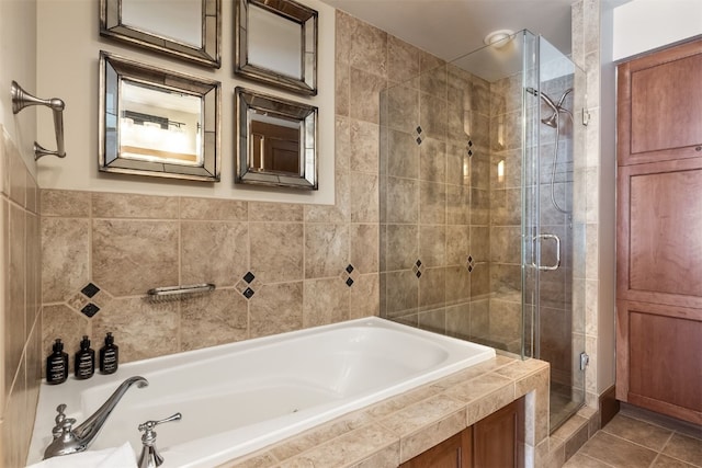 full bath featuring a garden tub, tile patterned flooring, and a shower stall