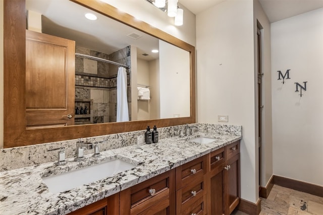 full bath with visible vents, baseboards, a sink, and tiled shower