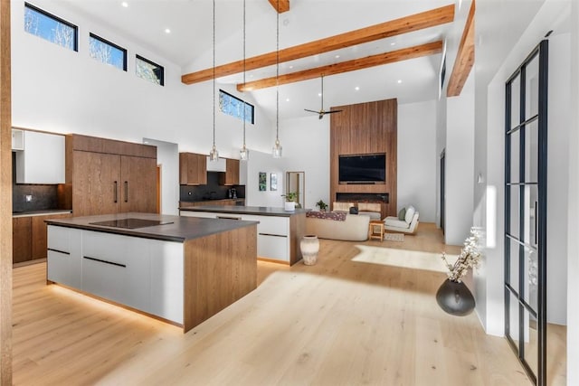 149 Game Trail Rd, Silverthorne, CO 80498 - kitchen featuring dark countertops, modern cabinets, a kitchen island, black electric stovetop, and high vaulted ceiling