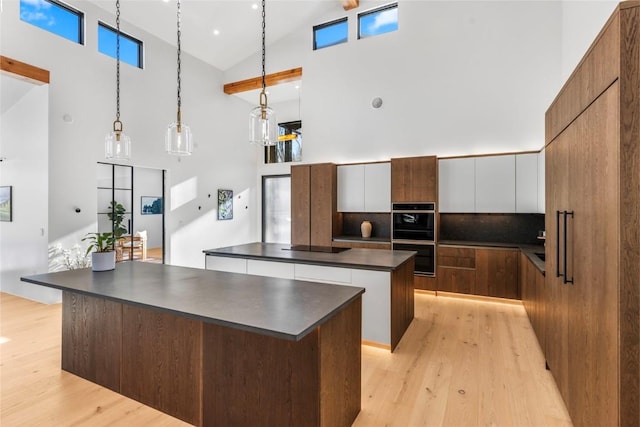 149 Game Trail Rd, Silverthorne, CO 80498 - kitchen with a large island, dark countertops, modern cabinets, multiple ovens, and high vaulted ceiling