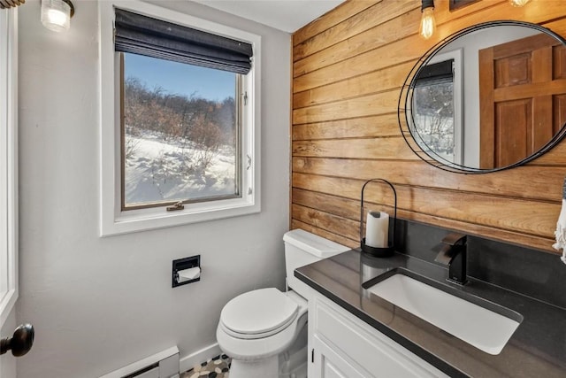 bathroom featuring baseboard heating, toilet, vanity, and wood walls