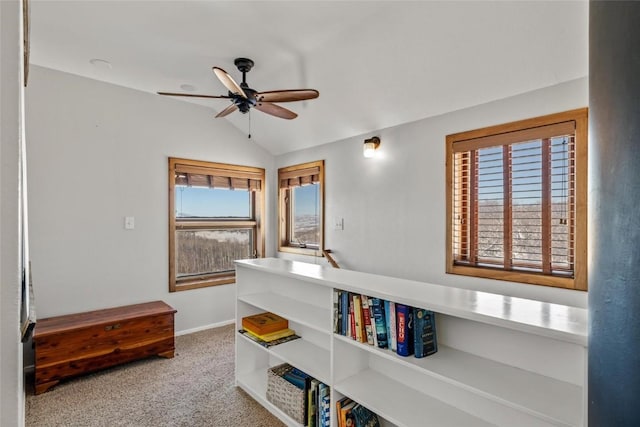 interior space featuring ceiling fan, vaulted ceiling, and carpet floors