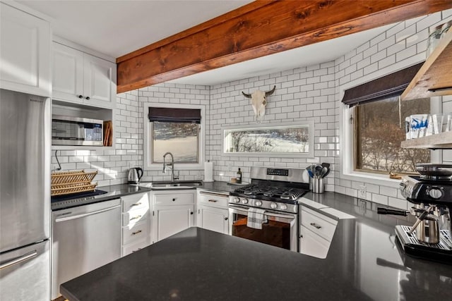 kitchen with stainless steel appliances, decorative backsplash, white cabinets, and sink