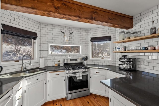 kitchen featuring white cabinets, appliances with stainless steel finishes, sink, backsplash, and light wood-type flooring