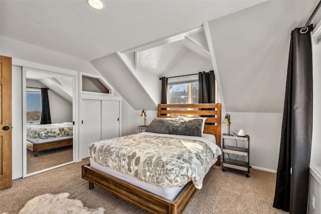 bedroom with vaulted ceiling, a closet, and light carpet