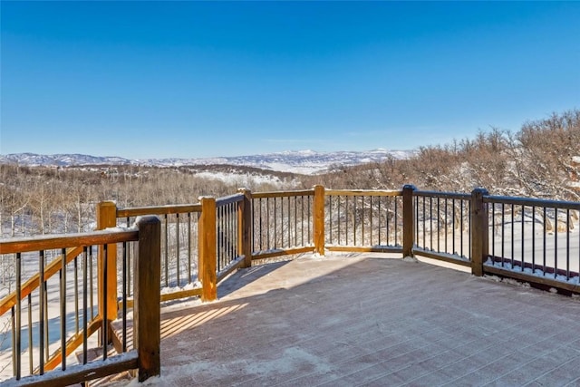 snow covered deck featuring a mountain view