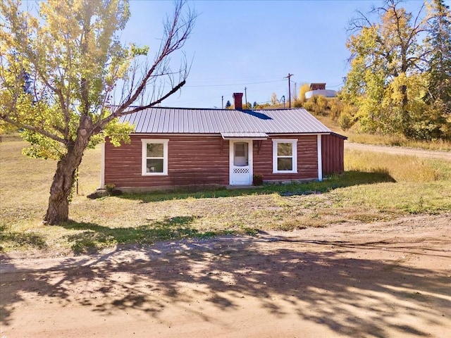 131 W Virginia St, Oak Creek, CO 80467 - view of front of home featuring log veneer siding, a chimney, and metal roof