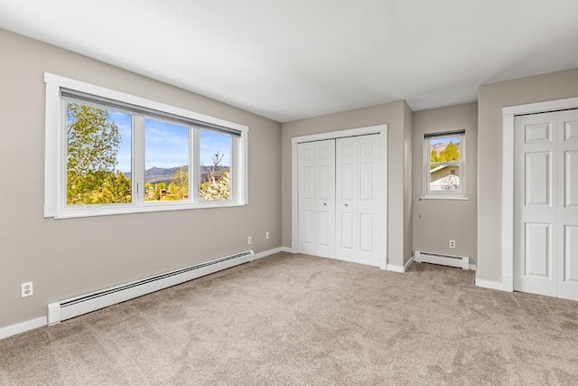 485 Amethyst Dr, Steamboat Springs, CO 80487 - unfurnished bedroom featuring baseboard heating, two closets, and multiple windows