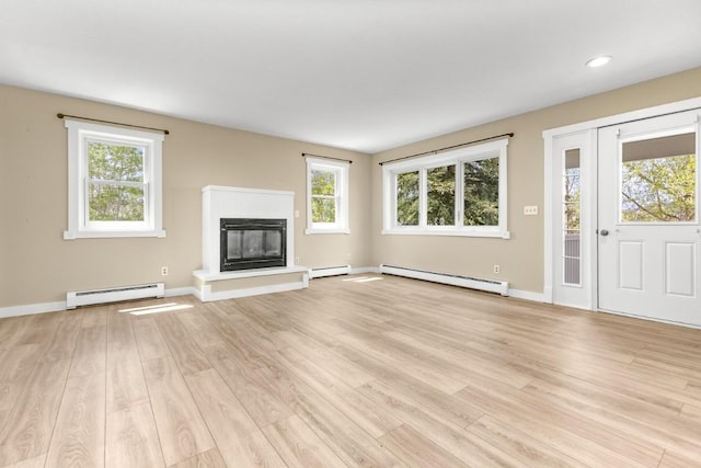 485 Amethyst Dr, Steamboat Springs, CO 80487 - unfurnished living room with a baseboard heating unit, a baseboard radiator, a glass covered fireplace, light wood finished floors, and recessed lighting