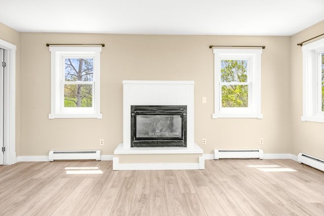 485 Amethyst Dr, Steamboat Springs, CO 80487 - unfurnished living room featuring baseboard heating, a baseboard radiator, wood finished floors, and healthy amount of natural light