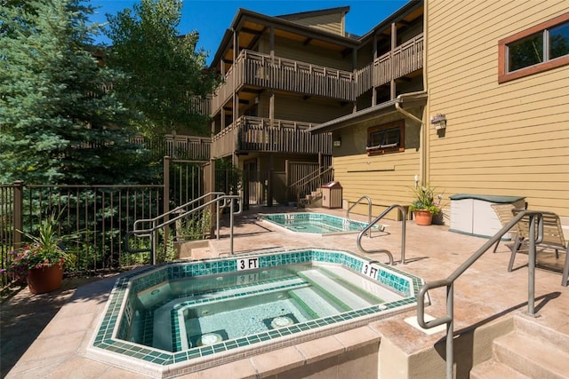 2700 Village Dr Unit B102, Steamboat Springs, CO 80487 - view of swimming pool featuring a hot tub, fence, and a patio