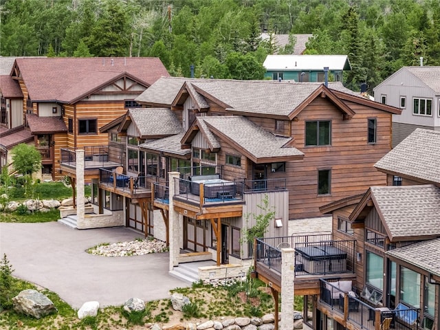 184 Caravelle Dr Unit 20, Keystone, CO 80435 - view of front of property with a shingled roof, a wooded view, stone siding, and a balcony