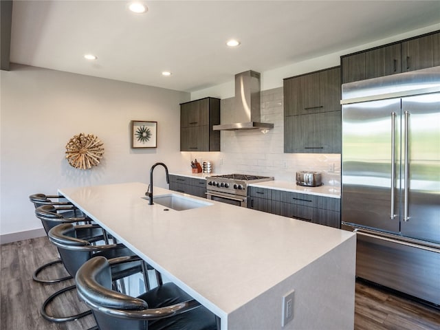 184 Caravelle Dr Unit 20, Keystone, CO 80435 - kitchen featuring wall chimney exhaust hood, premium appliances, dark wood-style floors, a breakfast bar, and recessed lighting