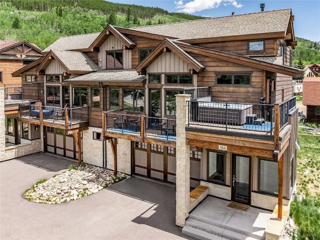 184 Caravelle Dr Unit 20, Keystone, CO 80435 - rear view of house with a shingled roof, board and batten siding, stone siding, and asphalt driveway