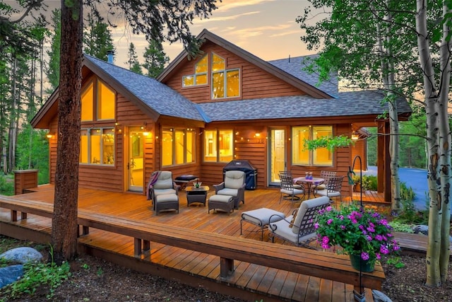 120 Windwood Cir, Breckenridge, CO 80424 - back of property at dusk featuring an outdoor living space, a wooden deck, outdoor dining area, and roof with shingles