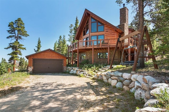 exterior space with stone siding, a chimney, a wooden deck, a garage, and an outdoor structure