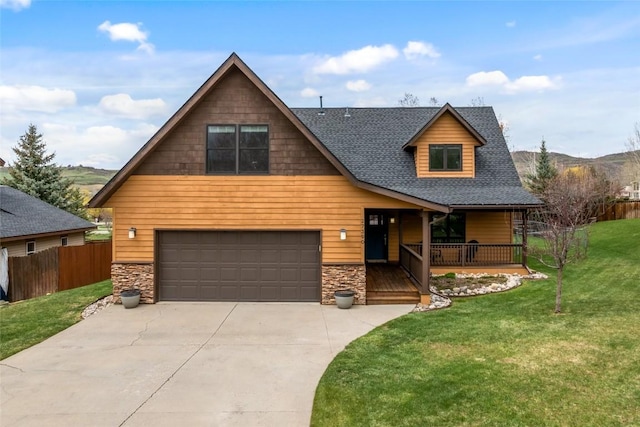 view of front facade with fence, a front lawn, stone siding, a garage, and a porch