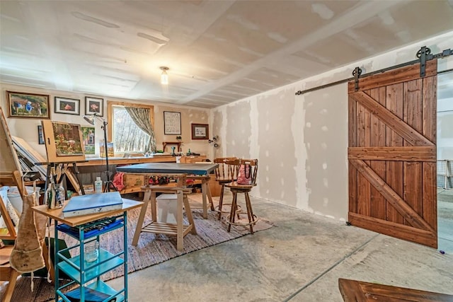 dining area featuring a barn door and concrete flooring