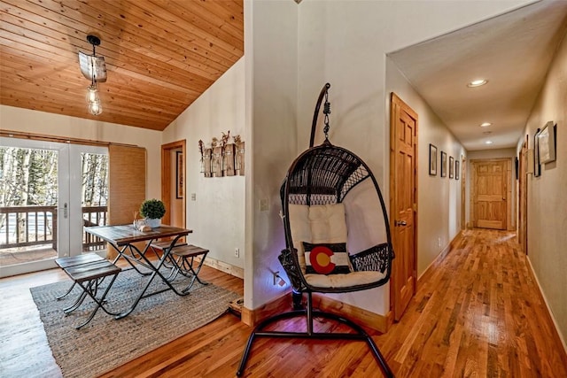 hallway with recessed lighting, wood finished floors, lofted ceiling, and baseboards