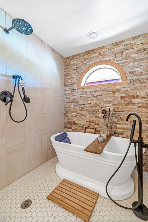 full bathroom featuring a freestanding bath, tile walls, and tiled shower
