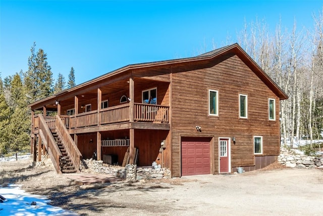 view of side of property with an attached garage and stairway