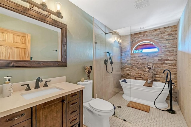 bathroom with visible vents, toilet, vanity, a walk in shower, and a soaking tub