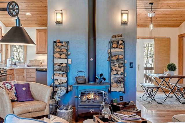 living room with wood ceiling, wood finished floors, and a wood stove