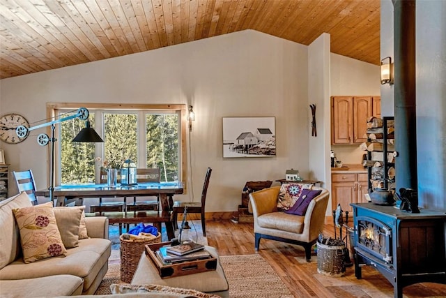 living area featuring wood ceiling, a wood stove, light wood-style flooring, baseboards, and lofted ceiling