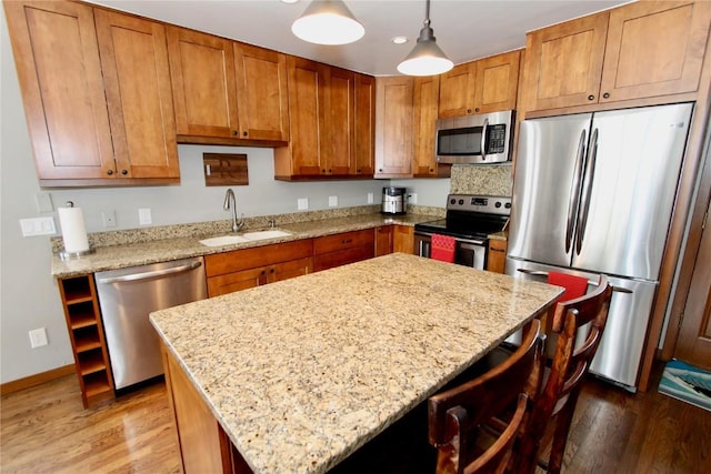 115 Beeler Pl Unit 1, Copper Mountain, CO 80443 - kitchen featuring brown cabinetry, light wood-style flooring, a sink, and appliances with stainless steel finishes