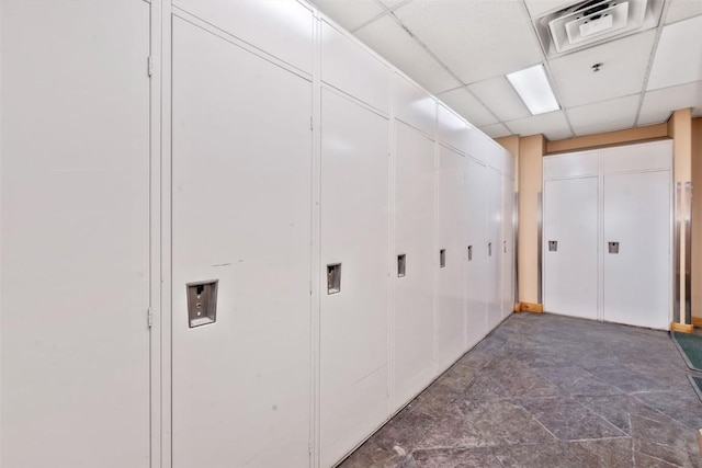 hall featuring a paneled ceiling